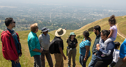 Group of family hikers at Sierra Vista overlooking cityscape below