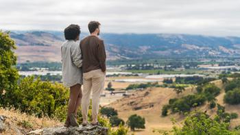 2 hikers with their backs to the camera overlooking a vista