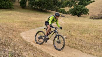 mountain biker in fluorescent green shirt on dirt trail