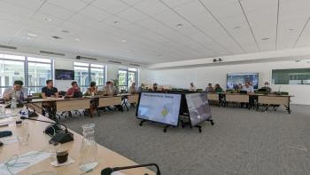 Leaders and researchers sit in a conference room for collaboration