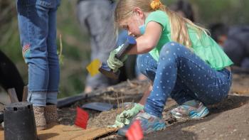 A child plants a plant in the ground