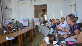 Jennifer Norris speaks into a microphone in a conference room in France