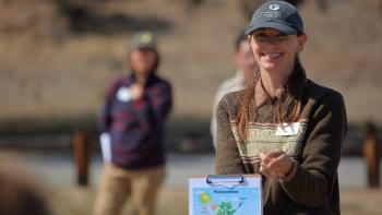 An instructor holds a clipboard that talks about photosynthesis