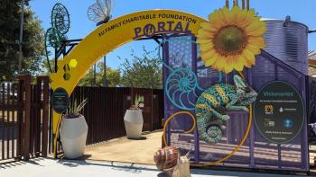 The entrance to an outdoor education area, with a bright yellow arch that reads "Xu Family Charitable Foundation Exploration Portal" surrounded by sculptural and cut-out shapes of a yellow flower, a blue and yellow chameleon, a snail, and a butterfly