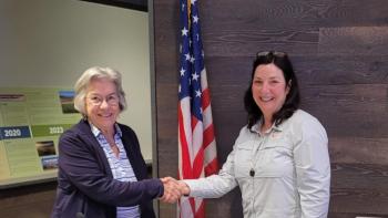 Director Matthews on the left shakes hands with Chair person Helen Chapman