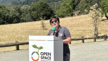 Andrea Mackenzie stands at Open Space Authority podium