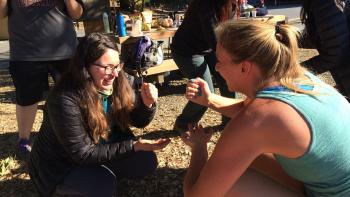 Two women kneeling and playing rock paper scissors