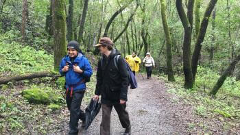 Two men walking together on a trail in the forest