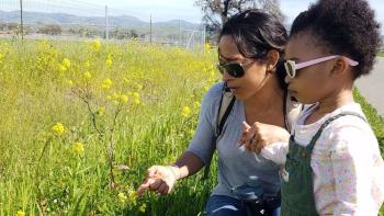 Mother and daughter looking at flowers in a field