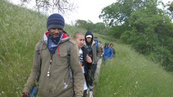 Group of people walking down a trail in a single file line