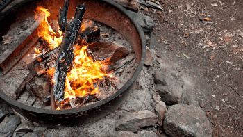 A fire ring contains burning wood and flames