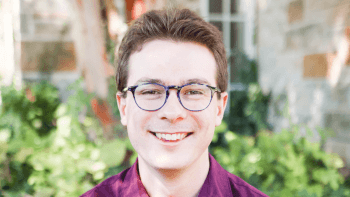 Headshot of a man with a red shirt and glasses