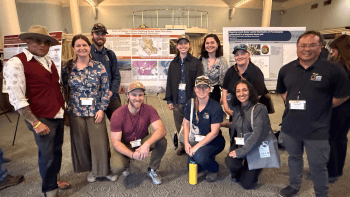 Open Space Authority staff stand around scientific posters at the Santa Cruz Mountains Stewardship Network's Science & Stewardship Symposium