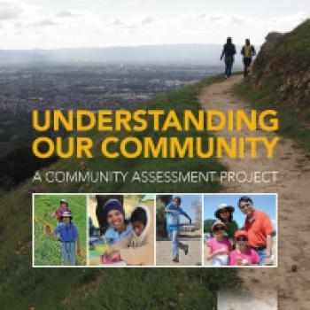 Report cover with yellow text that says "Understanding Our Community" over an image of a beautiful green landscape with hikers walking along a ridge and a college below of people in nature