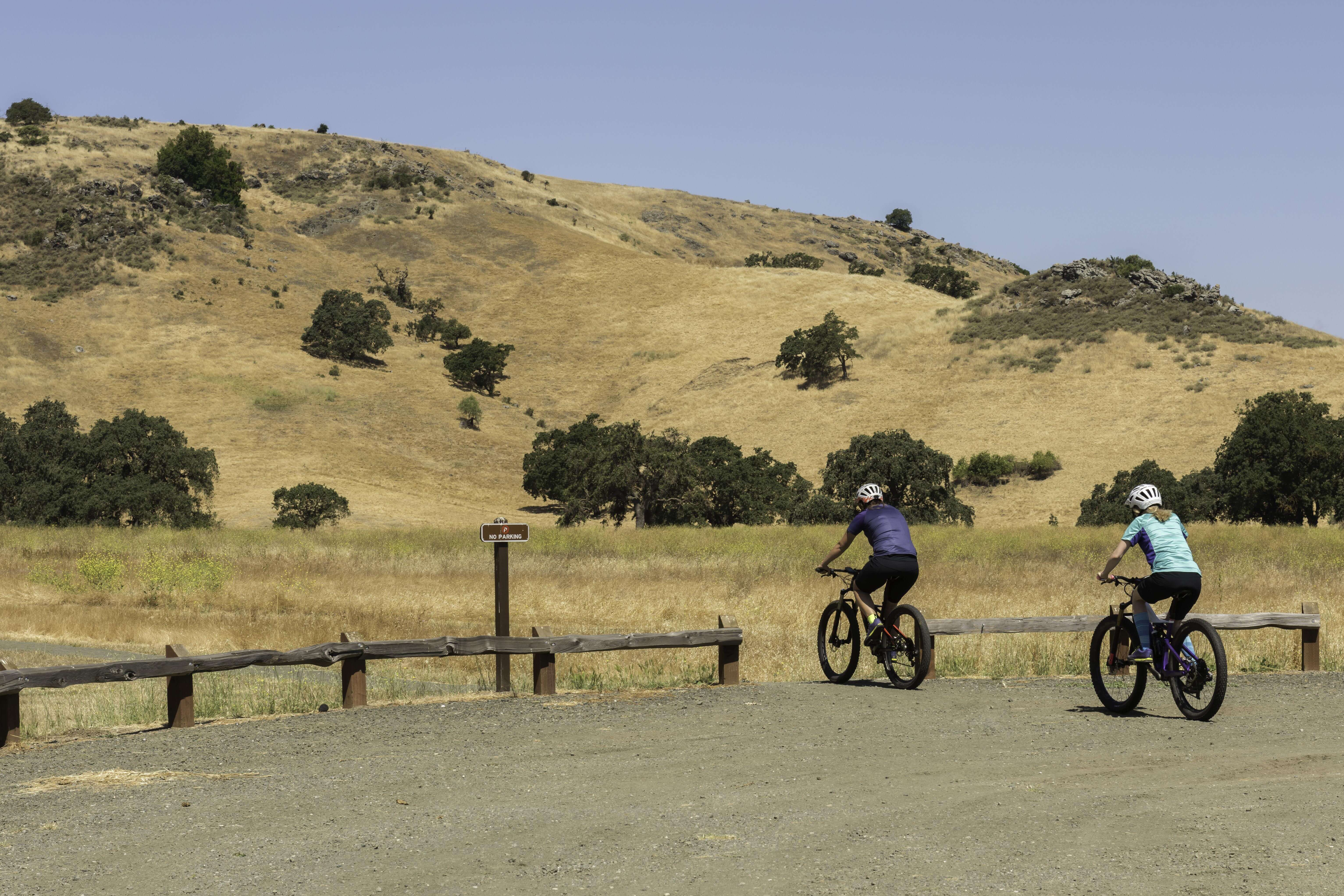 Two bikers head towards a trail at Coyote Valley OSP