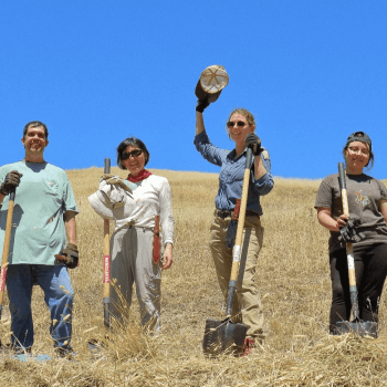 Volunteers pose for a photo on a golden hill at Furtado Barn