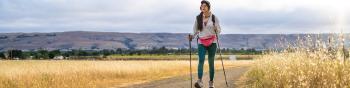 hiker with walking sticks on dirt trail