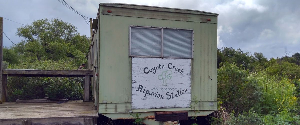 Small wooden building with "Coyote Creek Riparian Station" painted on front