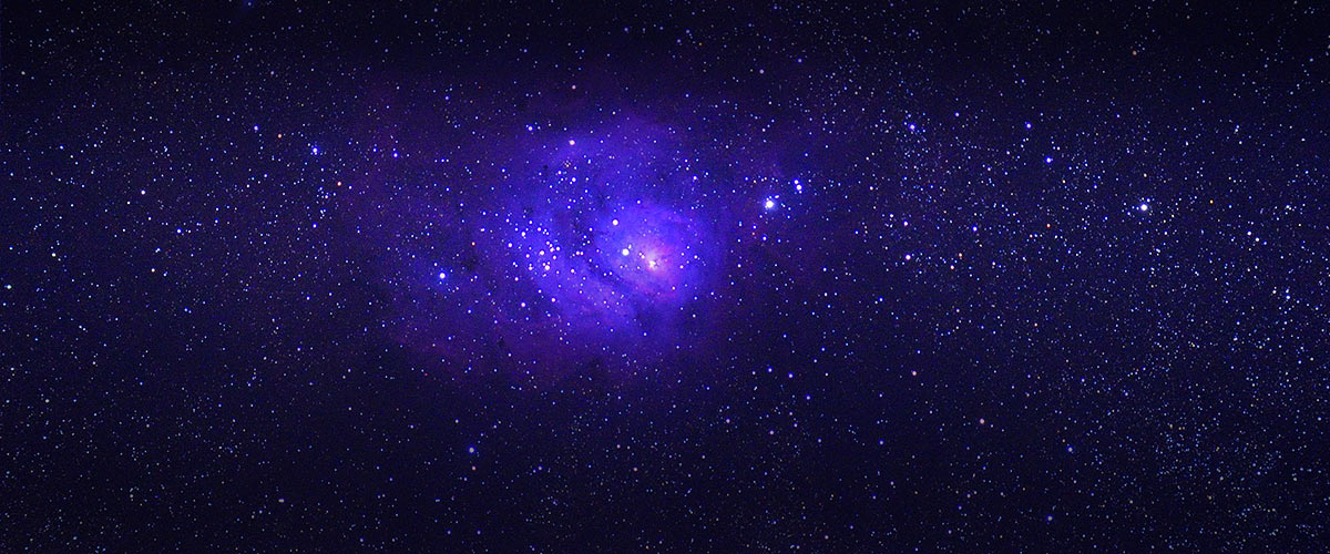 Purple nebula amidst sky of bright stars